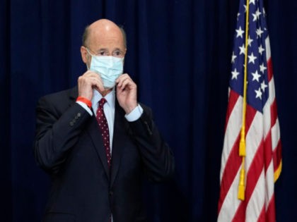 Pennsylvania Gov. Tom Wolf adjusts his face mask to protect against COVID-19 while attendi