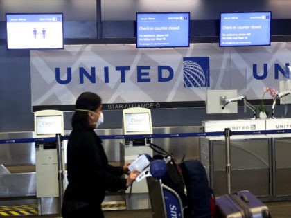 A United Airlines passenger pushes a luggage cart past closed check-in kiosks at San Franc