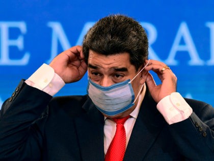 Venezuelan President Nicolas Maduro puts a face mask on after offering a press conference at Miraflores Presidential Palace in Caracas, on December 8, 2020. - President Maduro hailed a "new dawn" in Venezuela on December 7 as he celebrated his now total grip on power following a predictable triumph in …