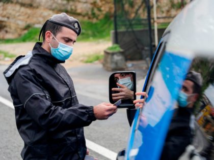 A member of the Lebanese security forces checks a citizen's documents at a COVID-19 checkp