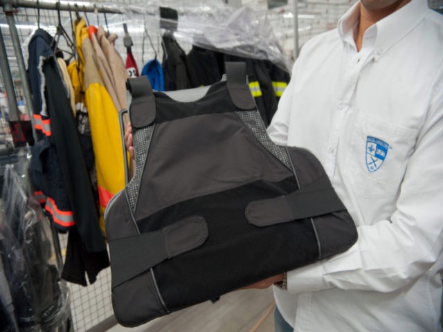 An employee shows a bulletproof vest, which is part of the armoured clothing line produced