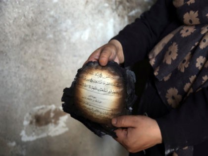 An Afghan woman holds a burnt copy of the Quran inside her house after Sunday's attack in Kabul, Afghanistan, Monday, July 29, 2019. A complex attack against the office of the president's running mate and a former chief of intelligence service Amrullah Saleh on Sunday in the capital Kabul, killed …