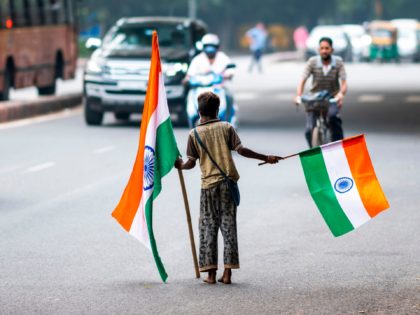 A boy selling Indian national flags looks for customers along a street ahead of the countr