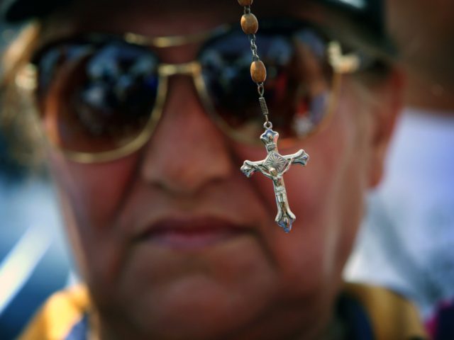 An Iraqi woman holds up a cross during a demonstration against the threat imposed by the Islamic State (IS) jihadists agasint Christians in northern Iraq, outside the UN office in Arbil, the capital of the autonomous Kurdish region on July 24, 2014. The United Nations Security Council has denounced militant …