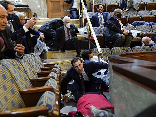 People shelter in the House gallery as protesters try to break into the House Chamber at t