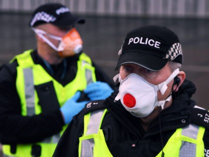 A police officer wwars a PPE face mask outside the Scottish Parliament as members of the public attend an anti lockdown protest held by The Scotland Against Lockdown group in Edinburgh, Scotland on January 11, 2021. (Photo by Andy Buchanan / AFP) (Photo by ANDY BUCHANAN/AFP via Getty Images)