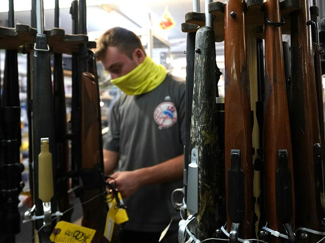A customer looks at long guns at Coliseum Gun Traders Ltd. in Uniondale, New York on September 25, 2020. - Gun store owners on Long Island have been selling out of firearms as scores of customers fear a rise in violence as the pandemic escalates in the area. (Photo by …