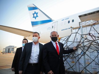 Israel's Prime Minister Benjamin Netanyahu (R) and Health Minister Yuli Edelstein (C) attend a ceremony for the arrival of a plane carrying a shipment of Pfizer-BioNTech anti-coronavirus vaccine, at Ben Gurion airport near the Israeli city of Tel Aviv on January 10, 2021. - Netanyahu announced earlier this week that …