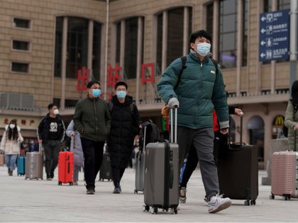 Passenger wearing face masks to help curb the spread of the coronavirus walk out from the
