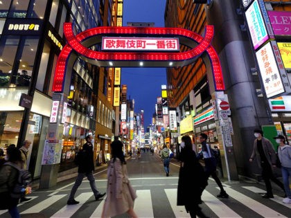 People cross a street at Tokyo's entertainment district Kabukicho on March 31, 2020. - Tokyo Governor Yuriko Koike on March 30 urged residents to stay away from karaoke parlours, bars and nightclubs to prevent the COVID-19 coronavirus from spreading. (Photo by Kazuhiro NOGI / AFP) (Photo by KAZUHIRO NOGI/AFP via …
