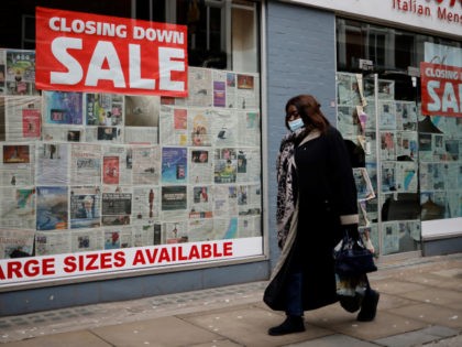 A pedestrian wearing a face mask as a precautionary measure against COVID-19, walks past a