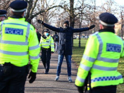 LONDON, ENGLAND - JANUARY 09: A protester does a star jumps in front of Police at Clapham Common during the anti-lockdown demonstration on January 9, 2021 in London, England. Chief Medical Officer Chris Whitty has filmed an advert for HM Government warning that people should stay home as the COVID-19 …