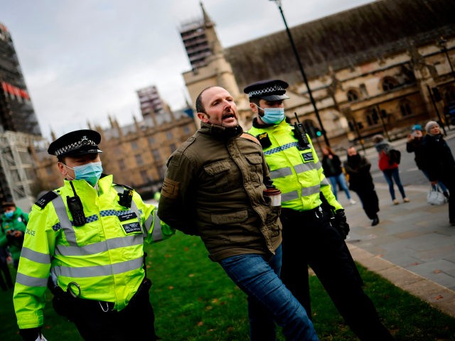 Police officers remove a protestor during an anti-COVID-19 lockdown demonstration outside the Houses of Parliament in Westminster, central London on January 6, 2021. - Britain toughened its coronavirus restrictions on Tuesday, with England and Scotland going into lockdown and shutting schools, as surging cases have added to fears of a …