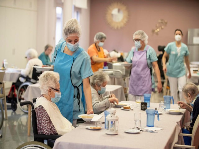 Medical personnel serve food during lunch time at a nursing home in Kaysesberg, eastern France, Monday Dec. 21, 2020. France is springing elderly residents from care homes for the holiday season. The aim is to alleviate some of the mental suffering and solitude of the coronavirus pandemic by letting care-home …