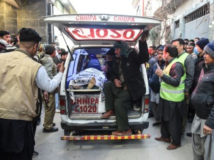 TOPSHOT - Members of a Shiite Hazara community sit next the coffin of their relative after