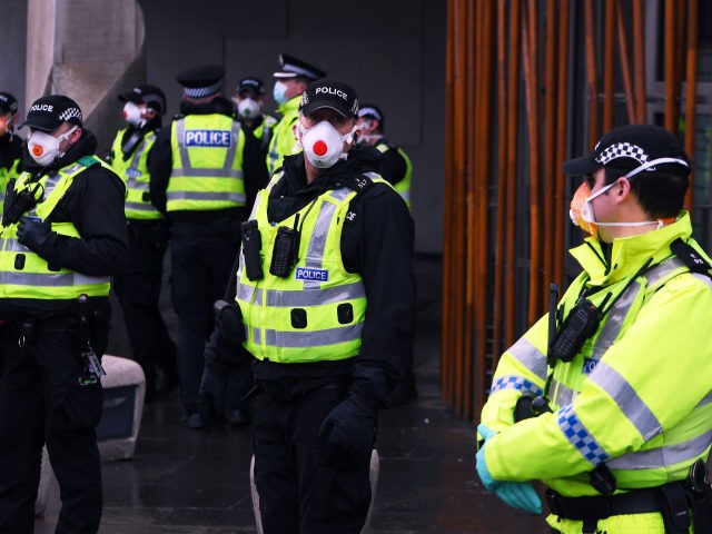 Police officers wearing PP face masks stand outside the Scottish Parliament as members of the public attend an anti lockdown protest held by The Scotland Against Lockdown group in Edinburgh, Scotland on January 11, 2021. (Photo by Andy Buchanan / AFP) (Photo by ANDY BUCHANAN/AFP via Getty Images)