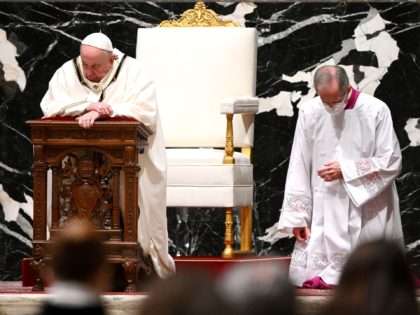 Pope Francis (L) prays as he leads a Christmas Eve mass to mark the nativity of Jesus Chri