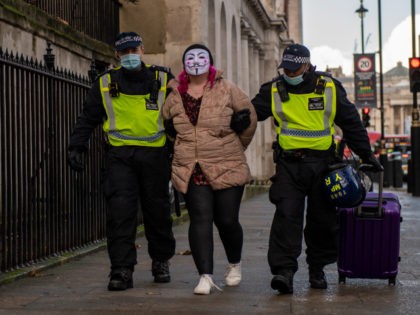 LONDON, ENGLAND - DECEMBER 19: A woman wearing a face mask is arrested during an anti lockdown protest on December 19, 2020 in London, England. With the majority of the United Kingdom now under the strictest tier 3 lockdown, Prime Minister Boris Johnson is due to hold a press conference …