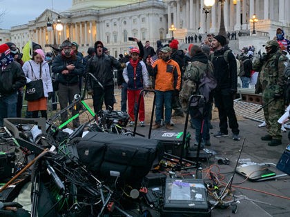 People stand around media equipment destroyed by Trump supporters outside the US Capitol i