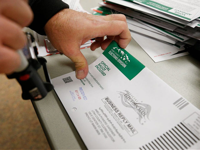 An election worker stamps a receiving date on mail-in ballots at the Salt Lake County elec