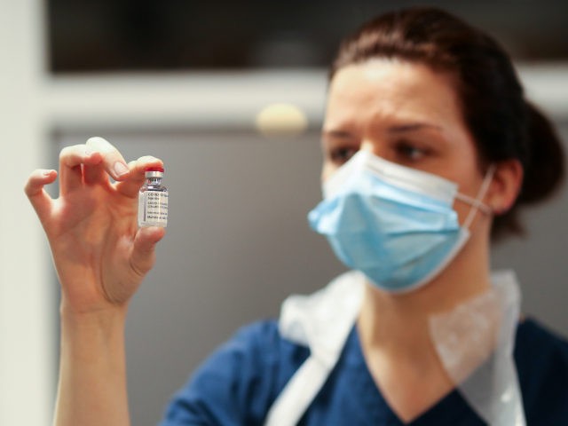 A healthcare worker poses with a vial of the Oxford/AstraZeneca coronavirus (COVID-19) vac
