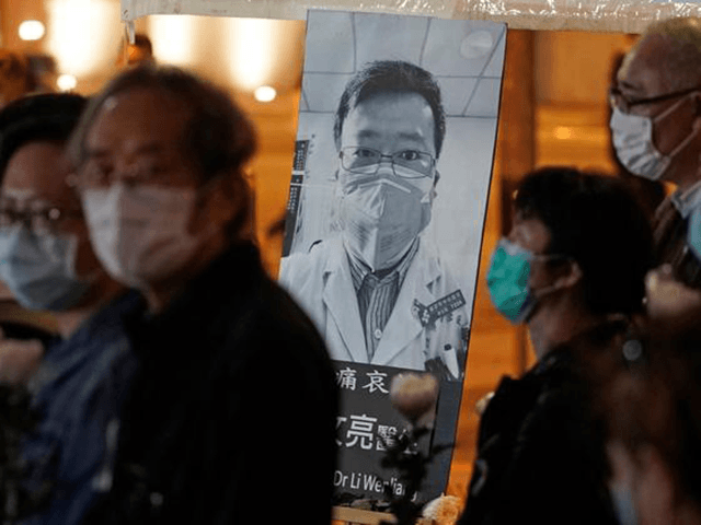 In this Feb. 7, 2020, file photo, people wearing masks attend a vigil for Chinese doctor L