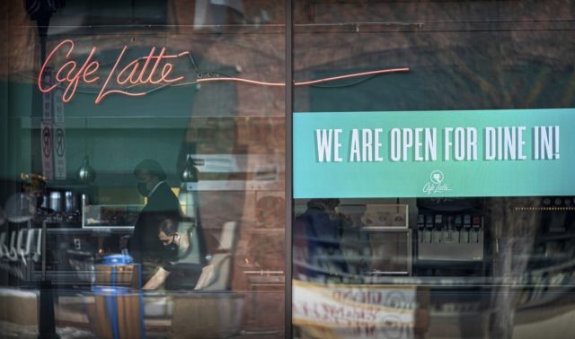Virus Outbreak Minnesota Cafe Latte on Grand Avenue, St. Paul had a sign in the window welcoming Dine In customers, on the first day of the new regulations, Monday, Jan. 11, 2021. (Glen Stubbe/Star Tribune via AP)
