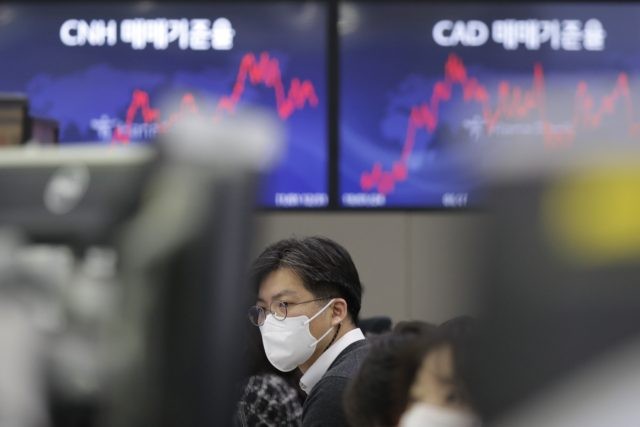 A currency trader watches computer monitors at the foreign exchange dealing room in Seoul, South Korea, Friday, Jan. 29, 2021. Asian stock markets were mixed Friday after Wall Street rebounded from its biggest loss in nearly three months, while Japan reported December factory output weakened. (AP Photo/Lee Jin-man)