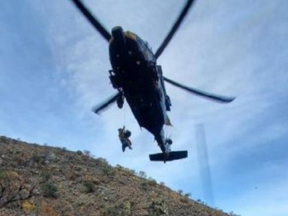 An Air and Marine Operations UH-60 Black Hawk helicopter rescue crew airlifts an injured migrant woman from a canyon near the Arizona border with Mexico. (Photo: U.S. Customs and Border Protection)