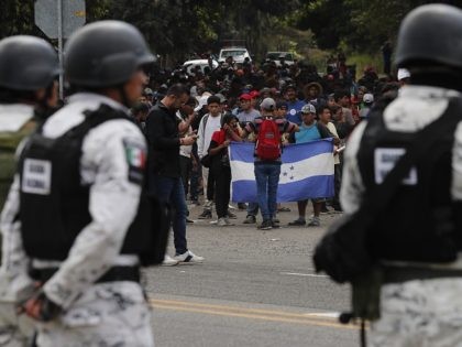 Mexican National Guards stand by as Central American migrants, who crossed the nearby border from Guatemala, stand on a highway leading to Tapachula, Mexico, Thursday, Jan. 23, 2020. Hundreds of Central American migrants crossed the Suchiate river into Mexico from Guatemala Thursday after a days-long standoff with security forces. (AP …