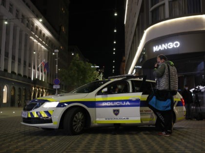 A pedestrian is checked by police in the main square, deserted, due to the COVID-19 restri