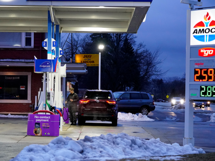 A customer checks gas price and ready to fill up a gas tank at the Amoco gas station in Gl