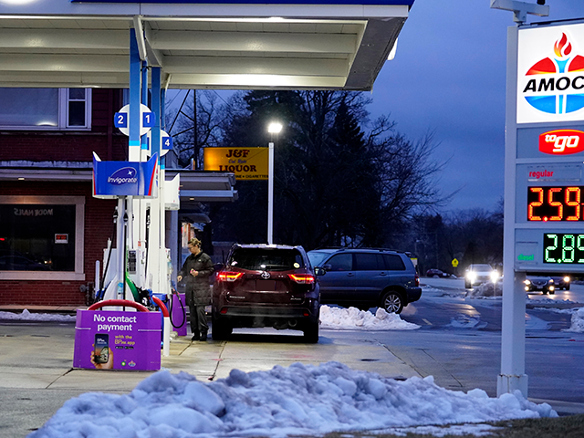 A customer checks gas price and ready to fill up a gas tank at the Amoco gas station in Glenview, Ill., Saturday, Jan. 16, 2021. Gas prices have gone up about 20 cents over the past month according to Gas Buddy analysts. (AP Photo/Nam Y. Huh)