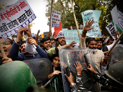 Security officers push back people shouting slogans during a protest held to show support to farmers who have been on a months-long protest, in New Delhi, India, Wednesday, Feb. 3, 2021. Nearly 200 supporters of Indian farmers on Wednesday clashed with the police who blocked them from marching to an …