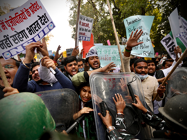 Security officers push back people shouting slogans during a protest held to show support