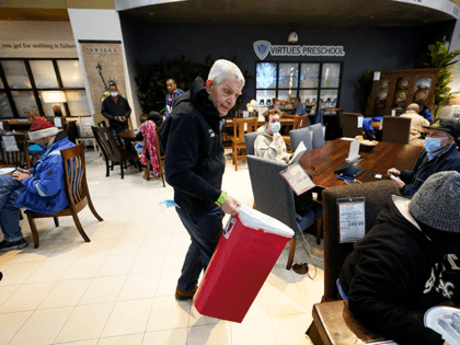 Owner Jim McIngvale collects trash inside his Gallery Furniture store which opened as a sh