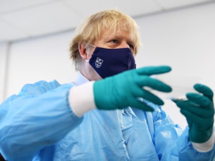 GLASGOW, SCOTLAND - JANUARY 28: British Prime Minister Boris Johnson is shown the Lighthouse Laboratory used for processing PCR samples, during a visit to the Queen Elizabeth University Hospital campus on January 28, 2021 in Glasgow, United Kingdom. Boris Johnson visits frontline keyworkers stating that there are great benefits of …