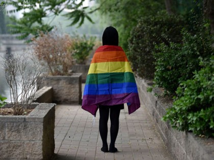 May 10, 2019, a gay student poses with a rainbow flag in Beijing. - China's LGBT community