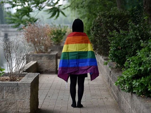 May 10, 2019, a gay student poses with a rainbow flag in Beijing. - China's LGBT community has had a tough year: Censors have shut down some of its social media forums, online news media have curbed coverage of gay issues, and online shops have removed sales of rainbow-themed products. …