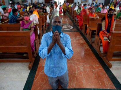 Christian devotees wearing facemasks as a preventive measure against the Covid-19 coronavirus offer prayers at Sacred Heart Shrine Church on Christmas in Chennai on December 25, 2020. (Photo by Arun SANKAR / AFP) (Photo by ARUN SANKAR/AFP via Getty Images)