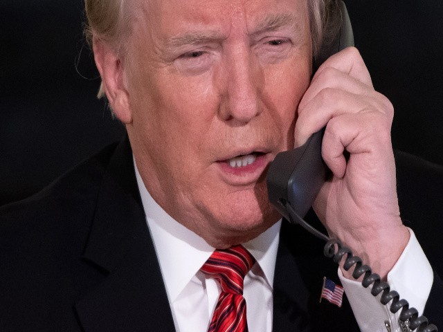 US President Donald Trump speaks on the telephone as he answers calls from people calling into the NORAD Santa tracker phone line in the State Dining Room of the White House in Washington, DC, on December 24, 2018. (Photo by SAUL LOEB / AFP) (Photo credit should read SAUL LOEB/AFP via Getty Images)
