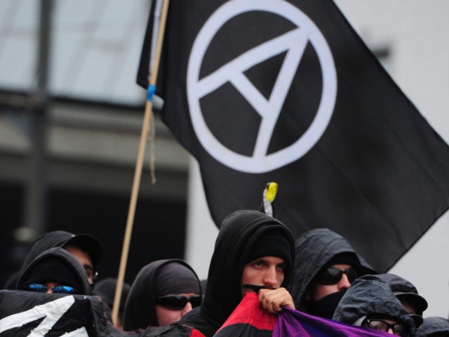 Left-wing protestors of the so-called black block hold a banner during a demonstration against the reunification celebrations on October 2, 2010 in the northern German city of Bremen as the country prepares to celebrate the 20th anniversary of the reunification of its western and eastern part on October 3, 2010. …