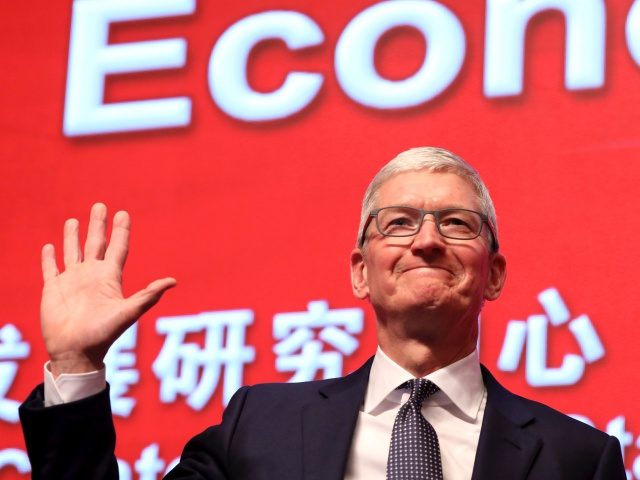 Apple CEO Tim Cook waves as he arrives for the Economic Summit held for the China Developm