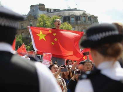 Counter-protesters hold up Chinese flags to oppose the protesters gathering in central London to attend a march organised by StandwithHK and D4HK in support of Pro-democracy protests in Hong Kong, on August 17, 2019. - Hong Kong's pro-democracy movement faces a major test this weekend as it tries to muster …