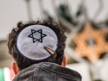 BERLIN, GERMANY - DECEMBER 22: A member of the Jewish community wears a Kippah during a ceremony to mark the beginning of Hanukkah at a public Menorah ceremony near the Brandenburg Gate on December 22, 2019 in Berlin, Germany. Jews around the world will celebrate Hanukkah, which this year runs …