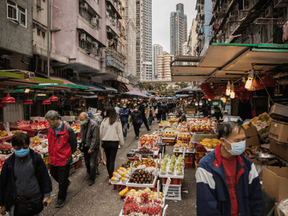 People wearing protective face masks shop at a fresh food market in Hong Kong on February 9, 2020, as a preventative measure after a coronavirus outbreak which began in the Chinese city of Wuhan. - The previously unknown virus has caused alarm because of its similarity to SARS (Severe Acute …