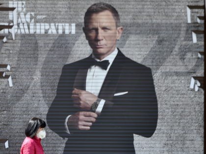 A woman wearing a face mask walks past an image of James Bond actor Daniel Craig in a shop window in the Ukrainian capital of Kiev on April 28, 2020, amid the COVID-19 coronavirus pandemic. (Photo by Sergei SUPINSKY / AFP) (Photo by SERGEI SUPINSKY/AFP via Getty Images)