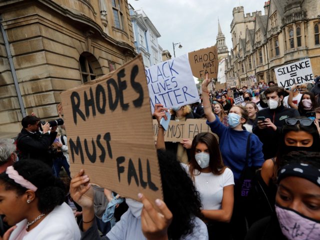 Protestors hold placards during a protest called by the Rhodes Must Fall campaign calling
