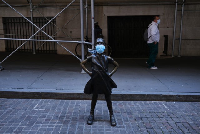 NEW YORK, NY - MAY 07: The Fearless Girl, a bronze statue created by Kristen Visbal and installed for International Women's Day, is shown with a surgical mask affixed across from the New York Stock Exchange (NYSE) on May 07, 2020 in New York City. The Nasdaq turned positive for …