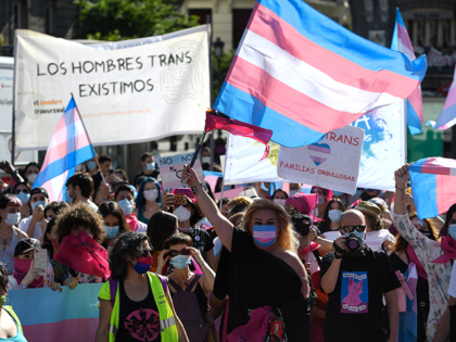 Protesters wearing face masks wave trans flags during a demonstration calling for more rights for transsexuals at Puerta del Sol in Madrid on July 4, 2020. (Photo by PIERRE-PHILIPPE MARCOU / AFP) (Photo by PIERRE-PHILIPPE MARCOU/AFP via Getty Images)